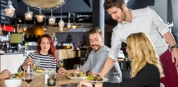 bigstock-Young-waiter-serving-food-to-c-115255127-1100x600-12-1